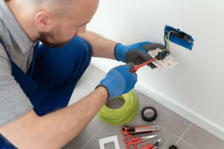 Electrician installing electrical outlet.