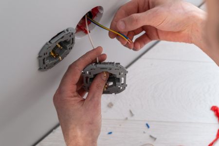 Electrician installing components in a wall.