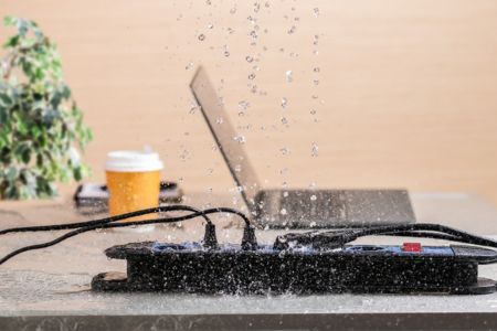 water splashing on the power strip, causing an electrical hazard on the desk