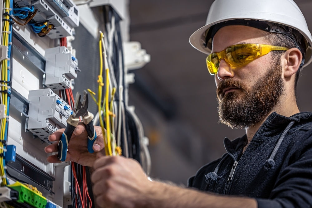 Electrician wiring up a whole home surge protector