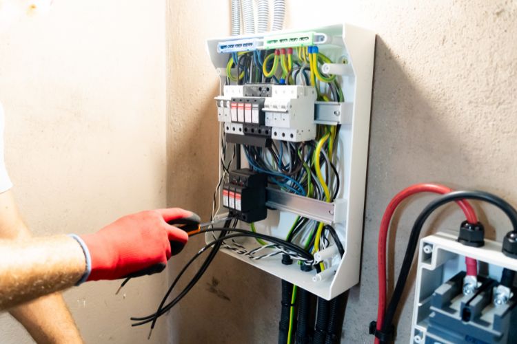 electrician wiring electrical panel for safe home power distribution